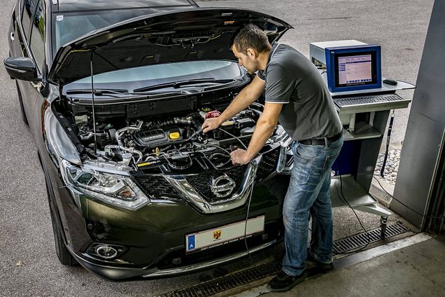 Fahrzeugtechniker untersucht den Motor eines Fahrzeuges